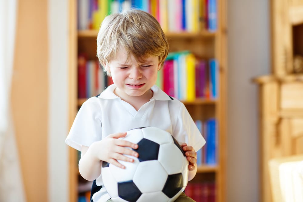 kid crying with ball