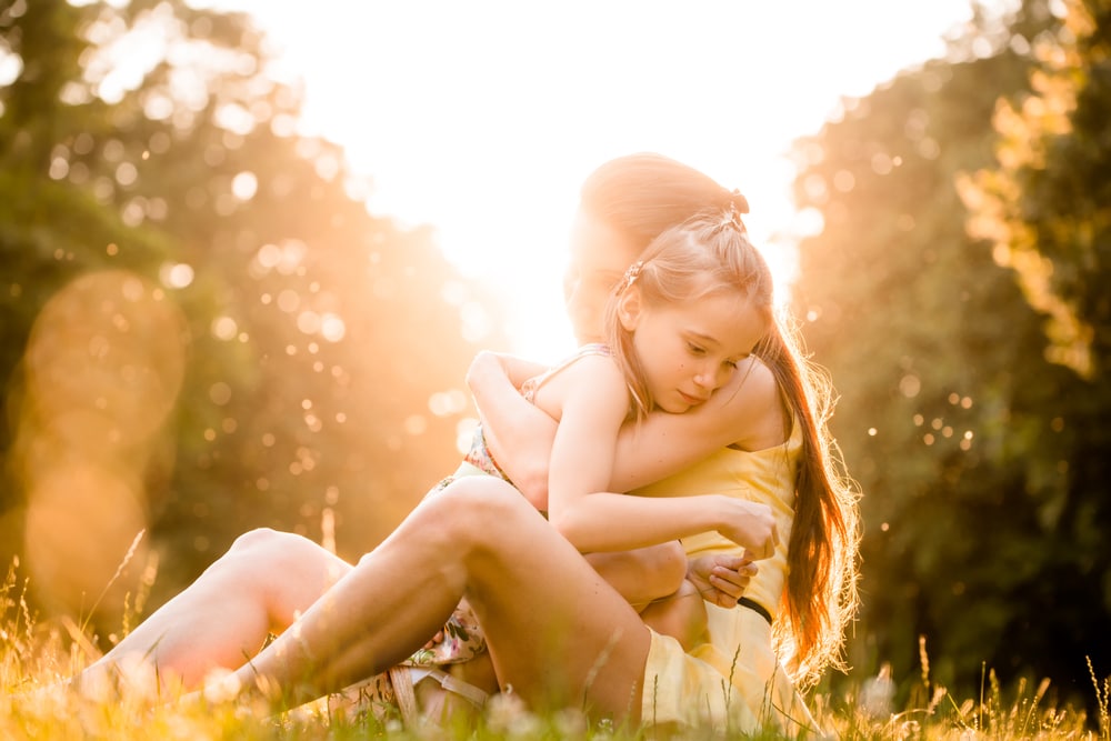 mother and kid embrace sun