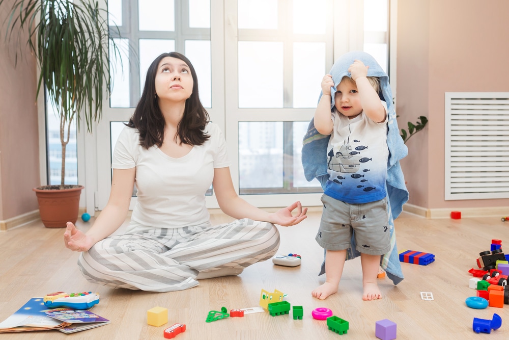 tired mother doing meditation with kid