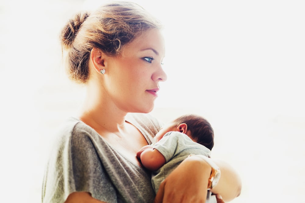 pensive woman with newborn