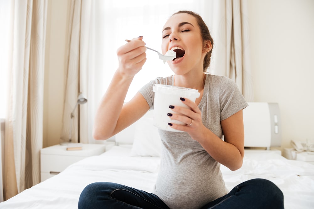 happy pregnant woman eating icecream