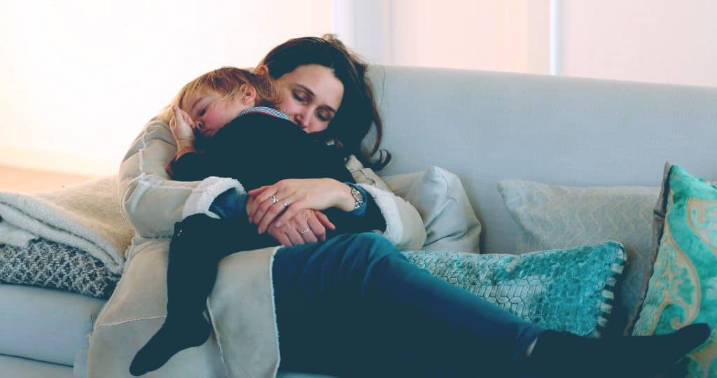 mother hold kid on couch